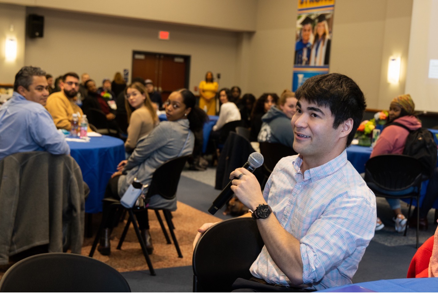 A student speaks into the microphone during a Social Justice Lecture.