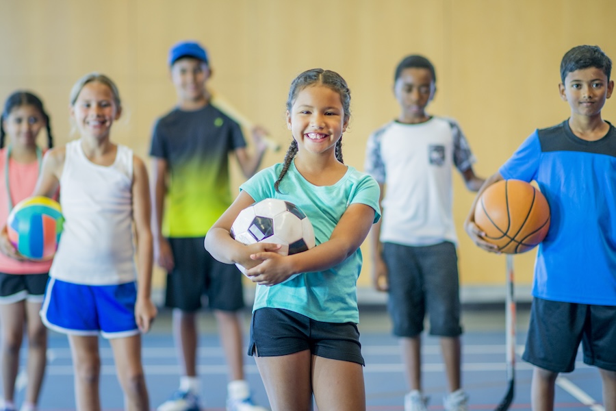 Children holding different sports balls