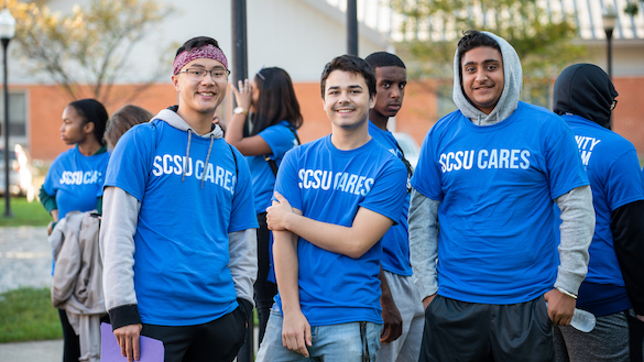 Three volunteers wearing SCSU Cares shirt