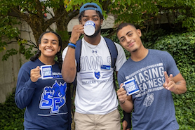 Three students wearing SCSU merchandise