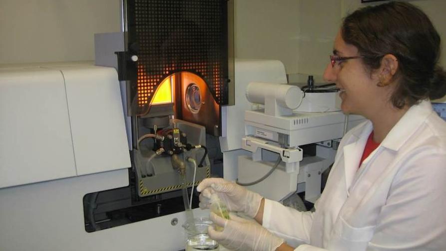 A student in a laboratory setting using equipment to conduct experiment