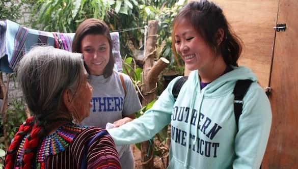 Two students with an older woman from another country